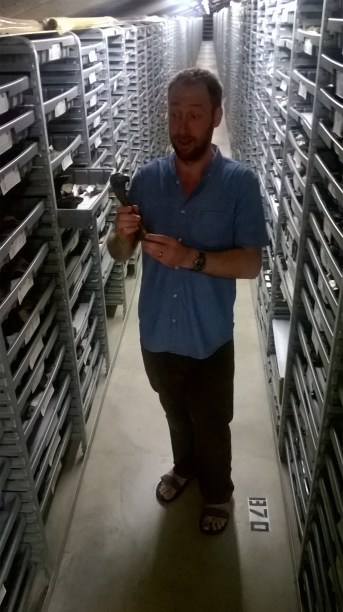 The author holding a bone from a dire wolf. You can see the extent of the drawers needed to store the collection. (Photo by Aisling Farrell)